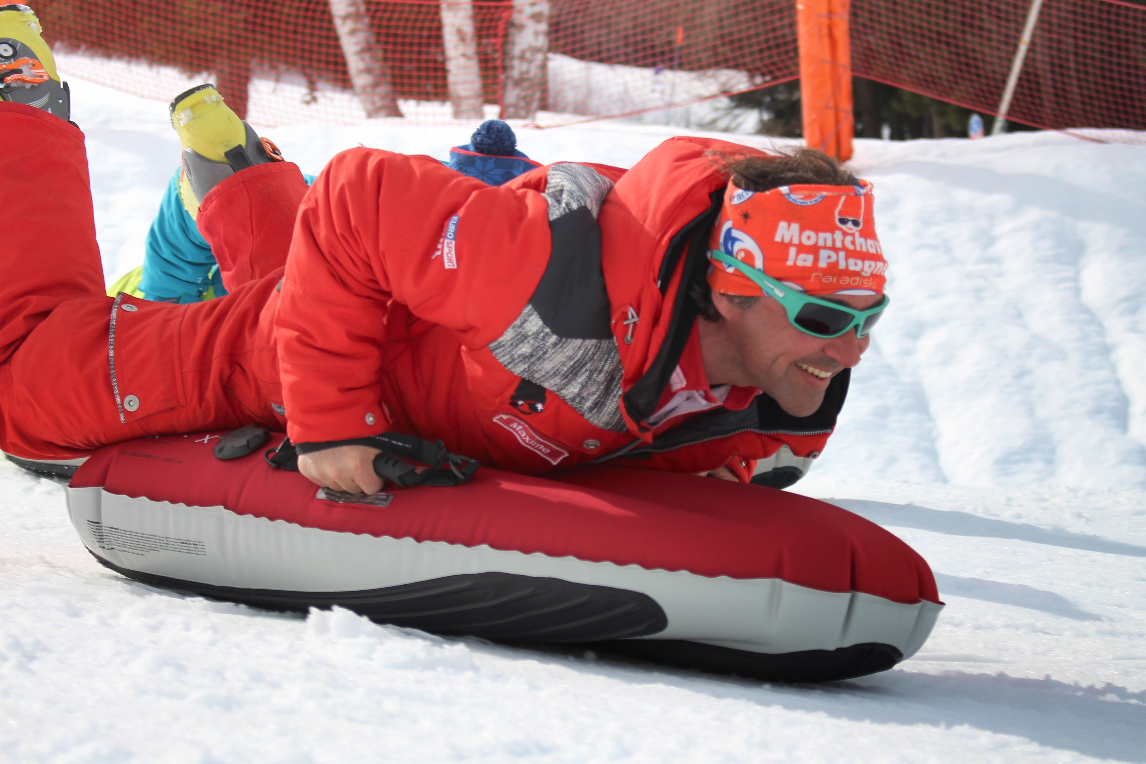 A person sledding on a snow tube.