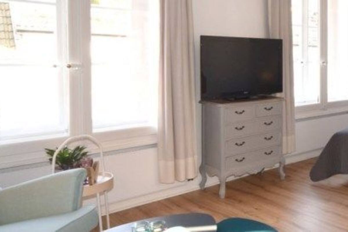 A bedroom with a bed, a television, a desk, and a chair.