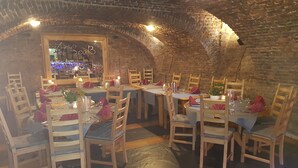 Un restaurante con paredes de ladrillo y mesas de madera dispuestas para comer.