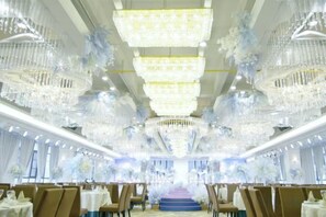 A banquet hall with multiple chandeliers, tables, and chairs arranged for a formal event. - Yu Long Jin Hotel (Ezhou)