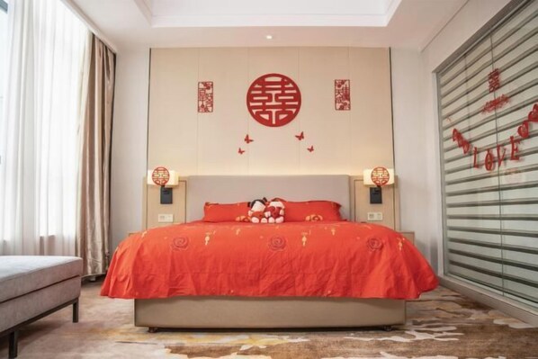 Quarto de hotel com cama, mesa de cabeceira e parede decorada.