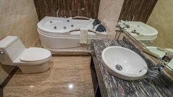 Une salle de bain comprenant des toilettes, une baignoire sur pieds et un lavabo avec un miroir.