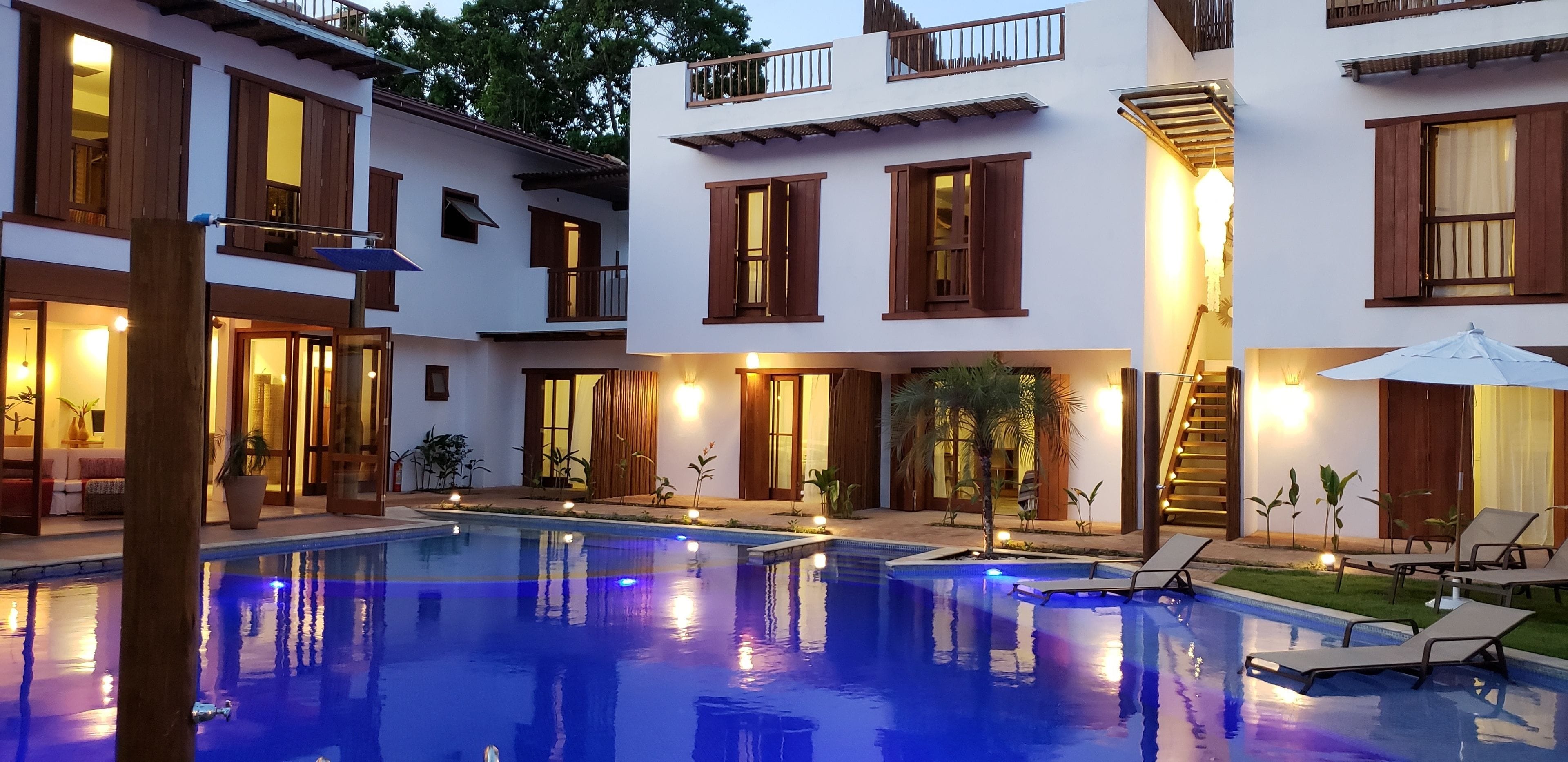 A pool area with a clear blue pool, wooden deck, and lounge chairs.