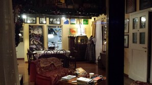 Una sala de estar acogedora con un sofá, una mesa de centro con libros y un comedor con mesa y sillas.