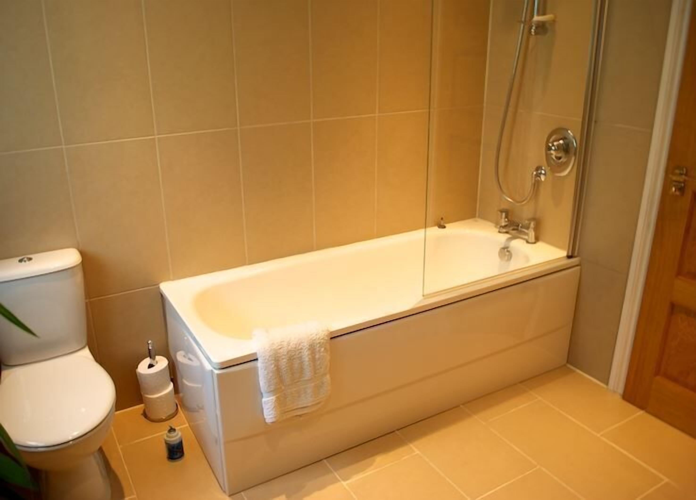 A bathroom with a bathtub, toilet, and shower.
