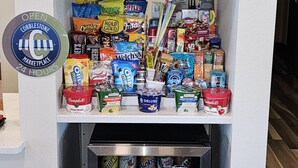 A vending machine stocked with snacks and drinks, a certificate of training, and a sign indicating the location is a 24-hour marketplace. - Cobblestone Inn & Suites – Manchester (Manchester)