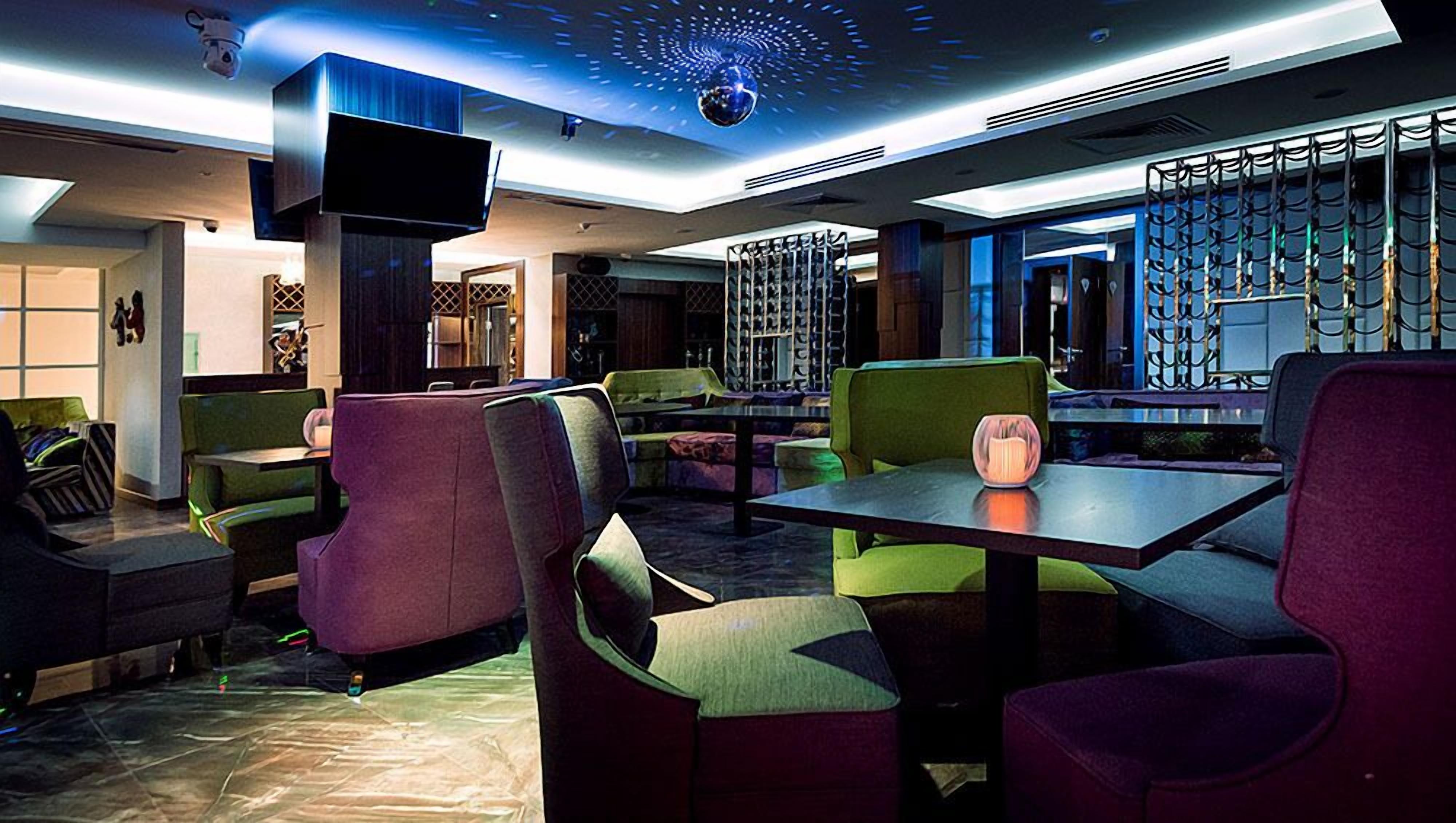 A modern interior with seating arrangements, a television, and a decorative ceiling feature.