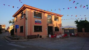 A two-story building with a sign for 'El Camino de Santiago' and outdoor seating. - El camino de Santovenia - Albergue - Hostel (Arlanzon)