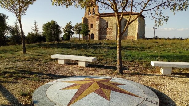 A stone church with a bell tower, surrounded by trees and grass. - El camino de Santovenia - Albergue - Hostel (Arlanzon)