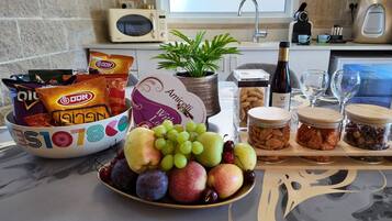 A kitchen counter with snacks, fruits, and condiments.
