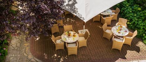 A patio area with wicker furniture and a large umbrella.