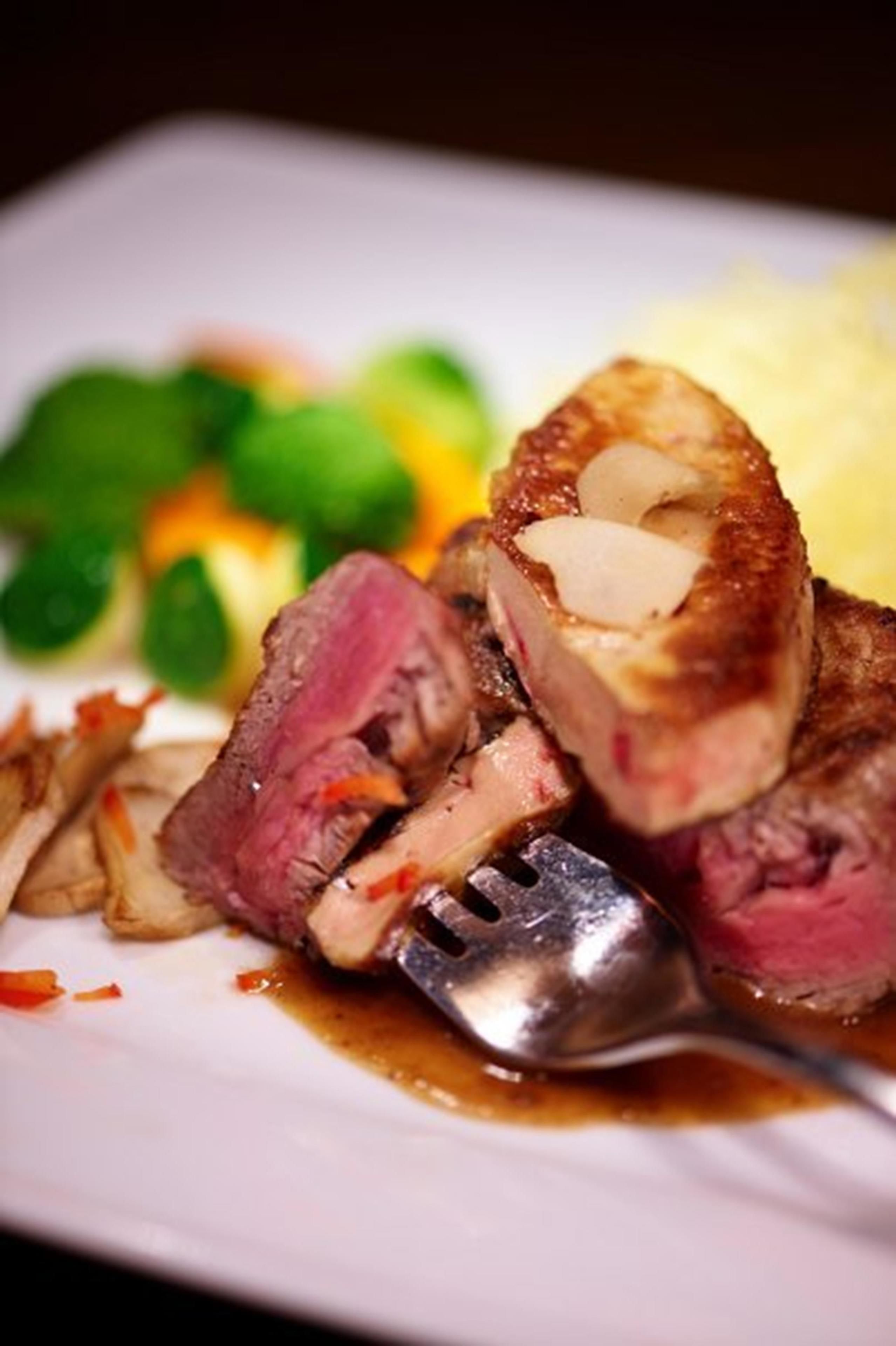 Ein Teller mit Essen, darunter geschnittenes Fleisch und Gemüse, sowie eine Gabel.