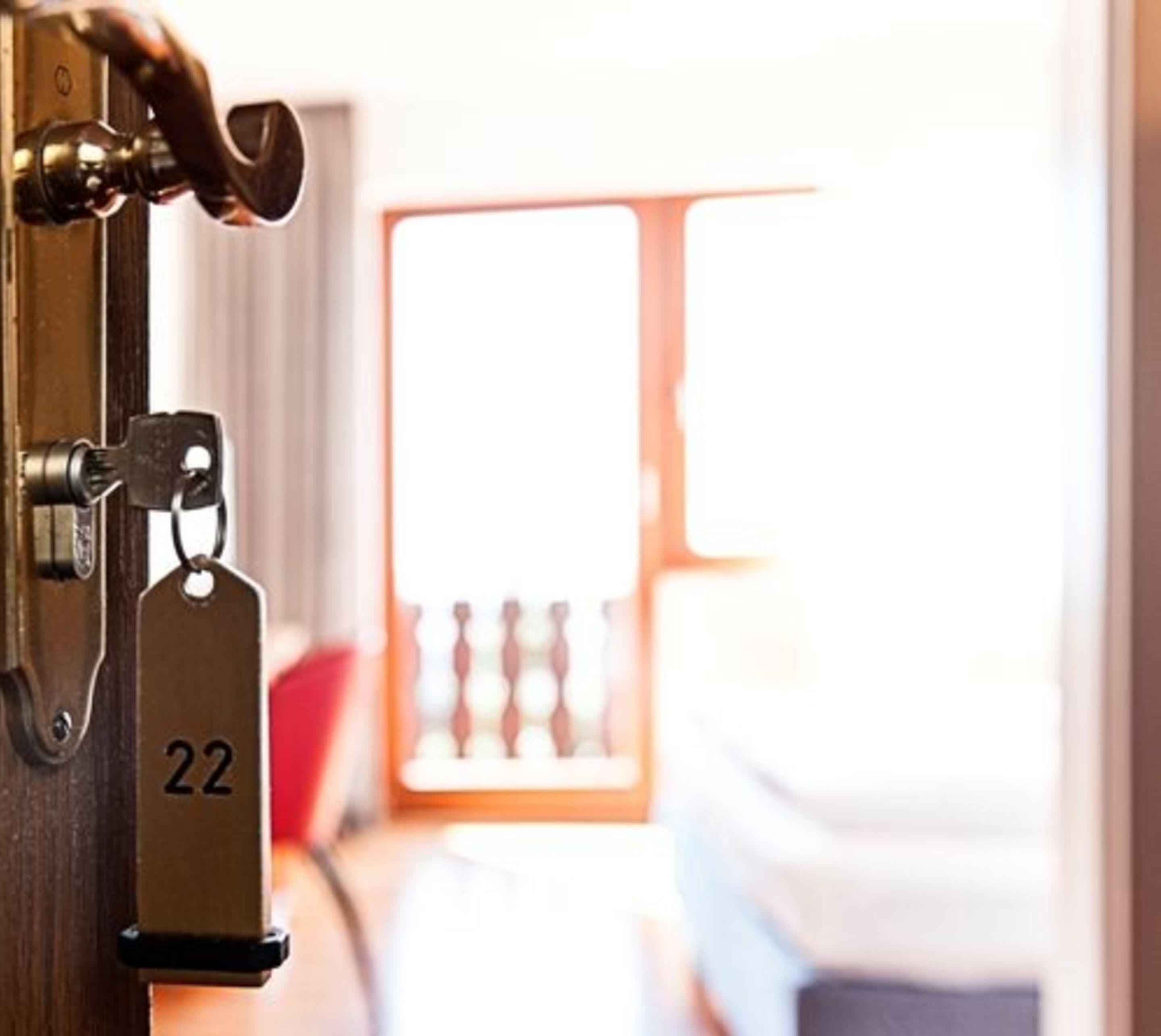 Une porte de chambre d’hôtel avec un trou de serrure et une étiquette indiquant le numéro de la chambre.