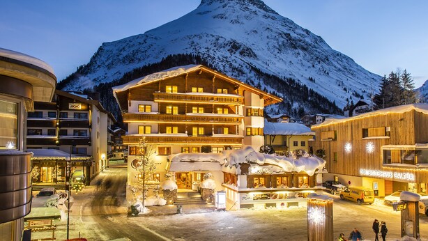 A snow-covered mountain with a wooden building featuring balconies and a sign reading "Bergendhaus Galtor". - Hotel Rössle (Galtur)