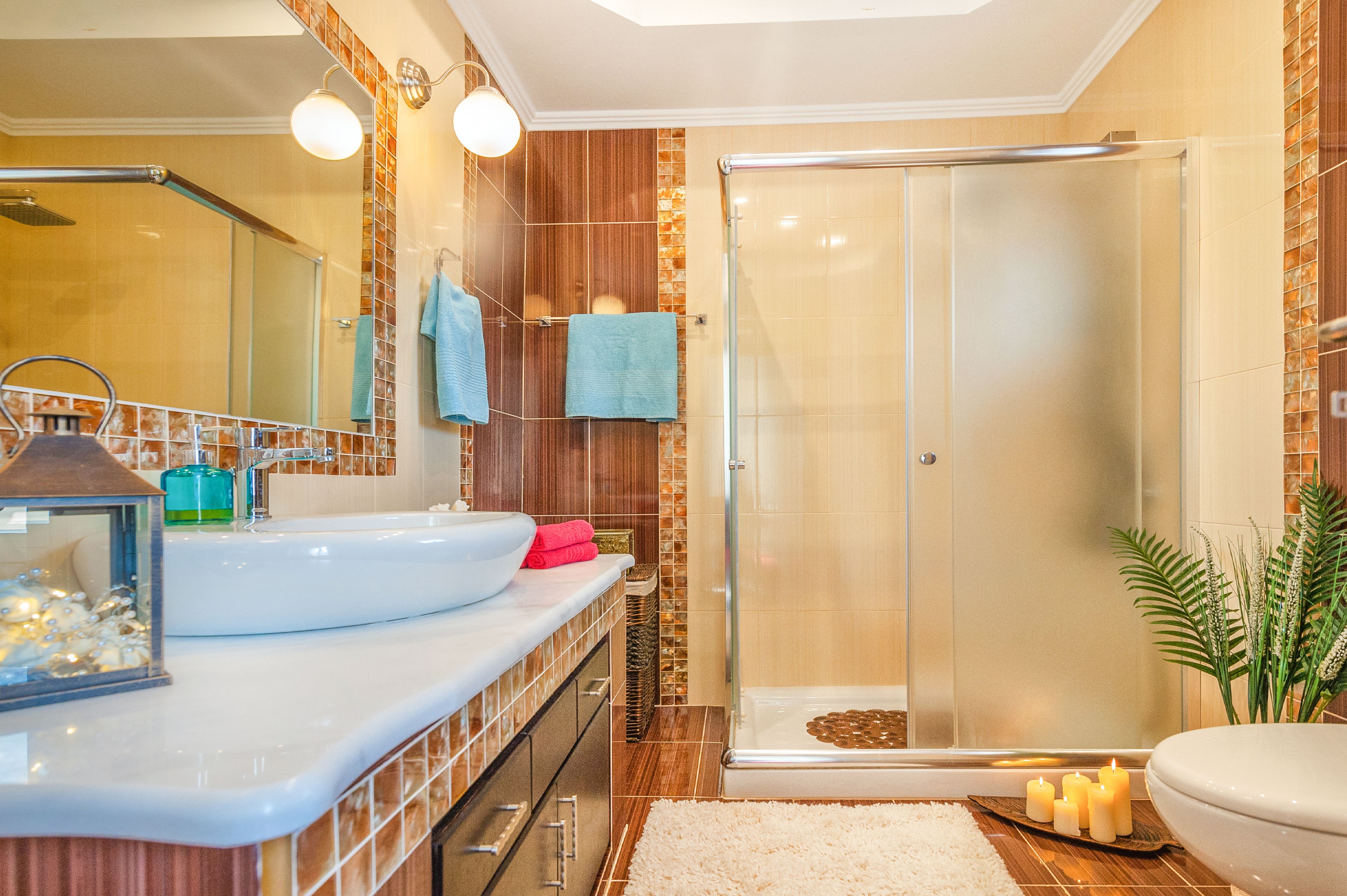 A modern bathroom with a glass shower enclosure, a large sink, and a mirror.