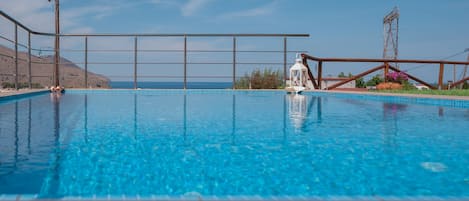 Piscine extérieure, parasols de plage, chaises longues