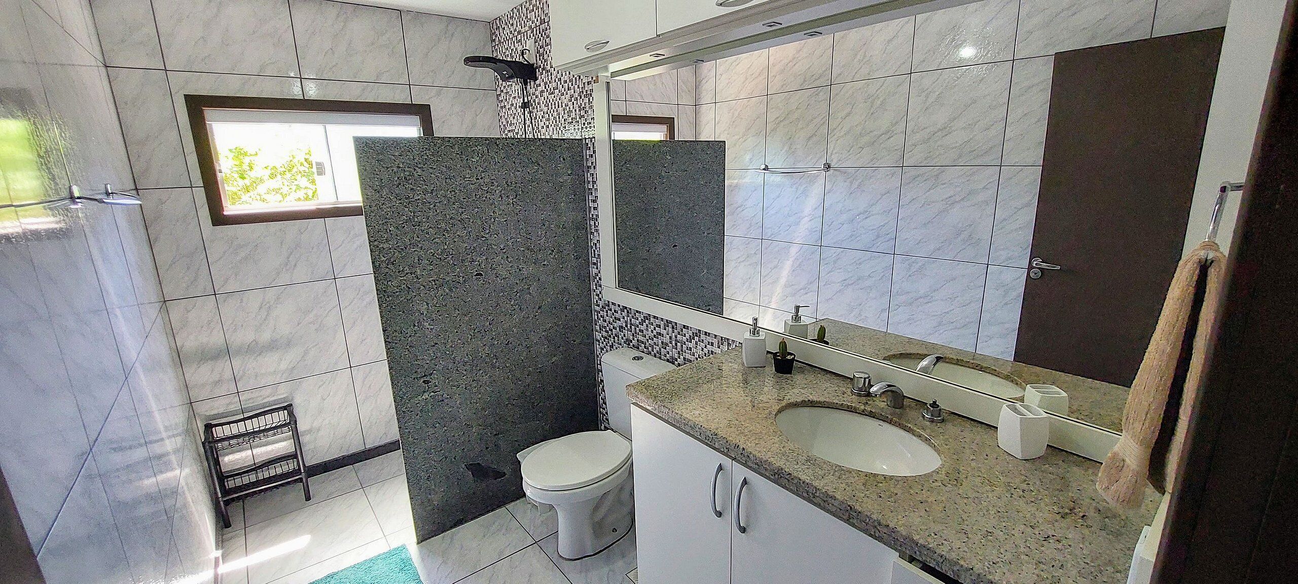 Une salle de bain avec deux lavabos, des toilettes, une douche et un miroir.