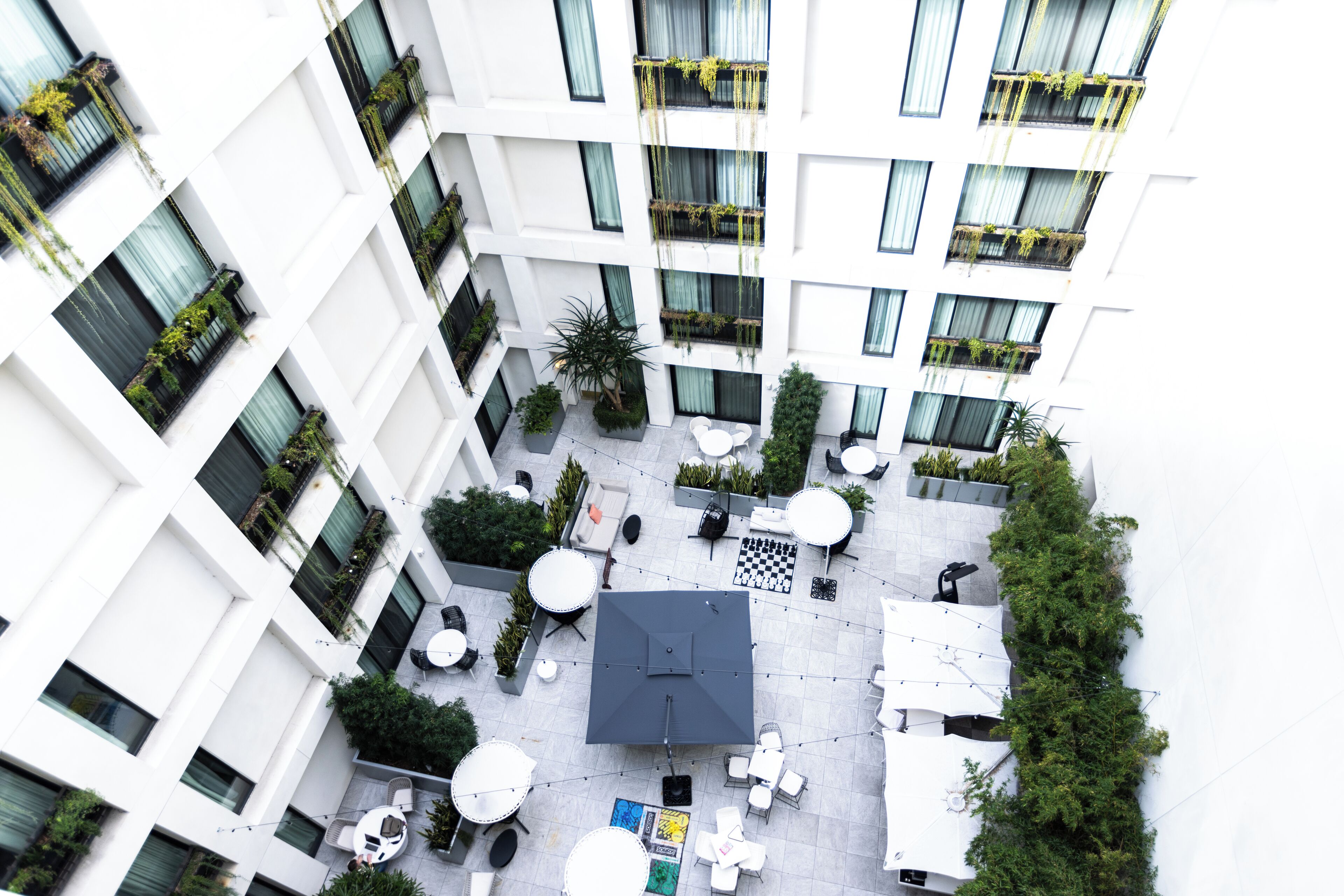 Un edificio moderno con varios balcones, zonas de estar al aire libre y plantas en macetas.