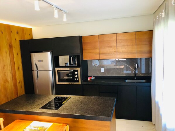 Una cocina moderna equipada con horno, microondas y refrigerador.