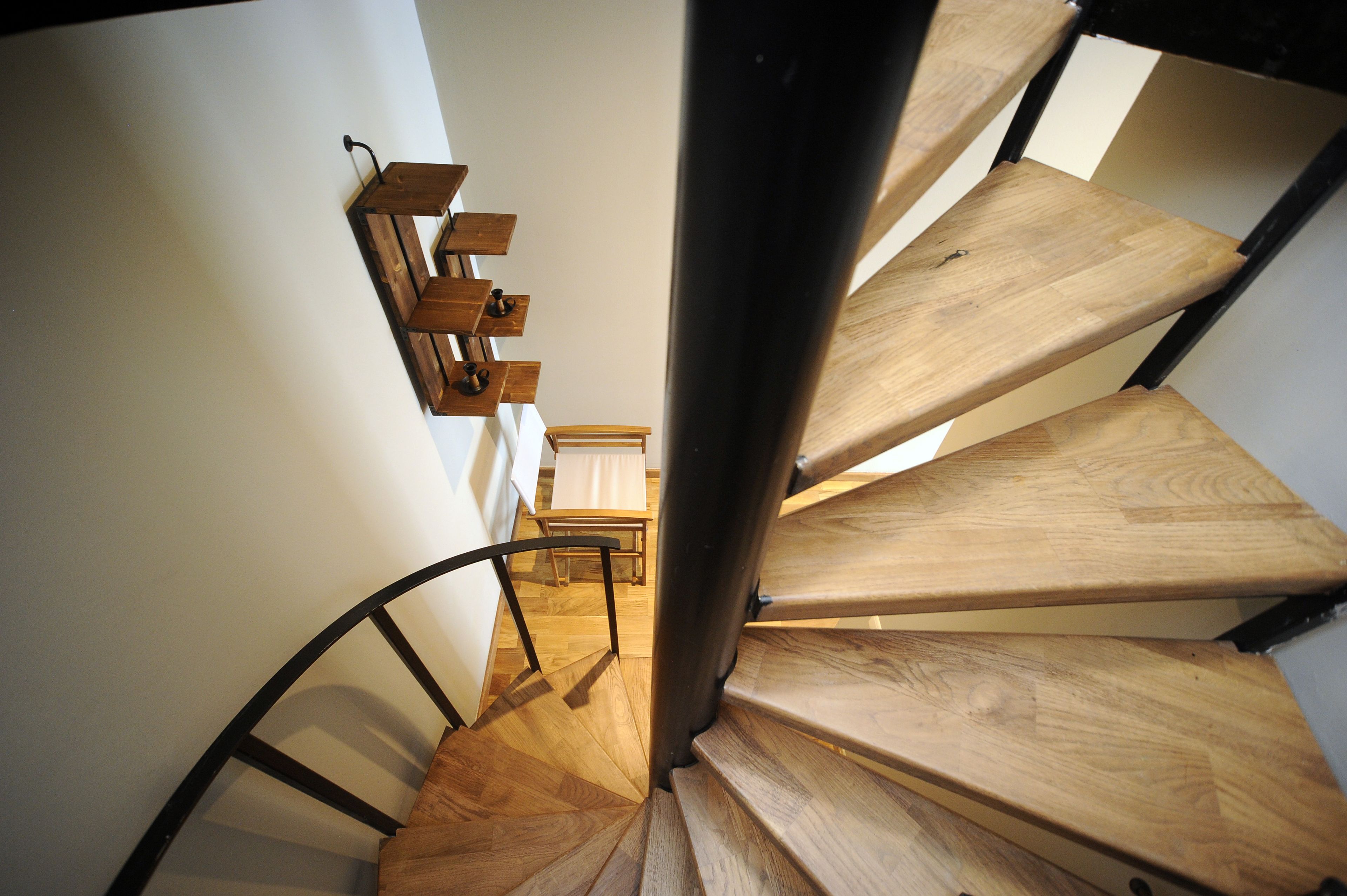 A spiral staircase with wooden steps and metal railings.