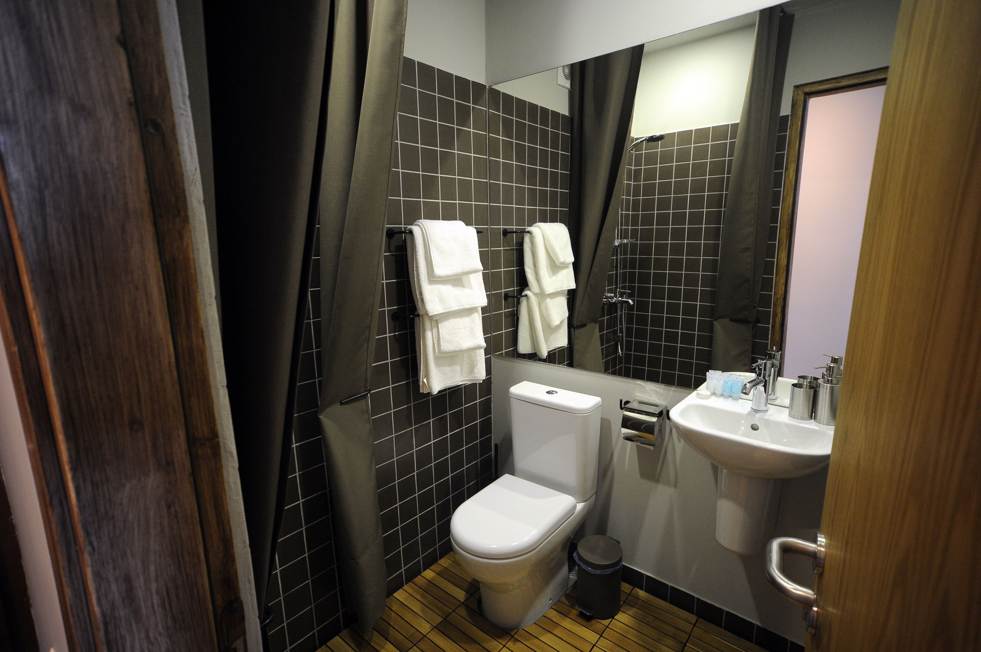 Une petite salle de bain comprenant des toilettes, un lavabo et un miroir.