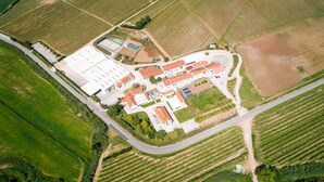 Vista aérea de una gran instalación industrial con varios edificios, caminos y campos agrícolas circundantes.