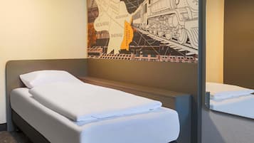 Ein Hotelzimmer mit Bett, Kopfteil, einer Wand mit einer Karte und einem Spiegel.