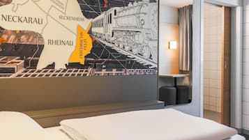 Una habitación de hotel con una cama, un mapa de pared y una lámpara.