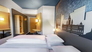 Una habitación de hotel con una cama, un escritorio y un mapa colgado en la pared.