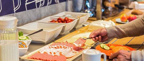 Buffet com diversas opções de comida, incluindo carnes, frutas e acompanhamentos.