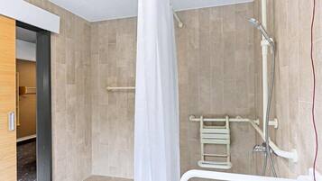 Un bagno moderno con doccia, maniglie di sostegno e portasci.