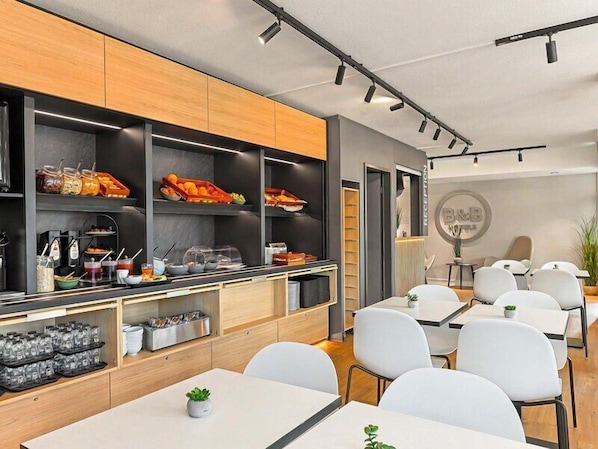 A modern reception area with a reception desk, seating area, and a buffet counter with various food items.