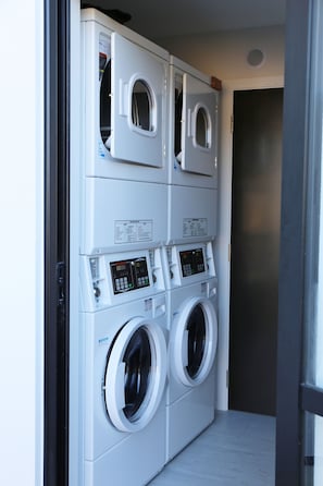 Efficient laundry facility with a stacked washer and dryer unit featuring a digital control panel.