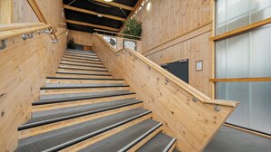 A wooden staircase with metal railings and a grey carpeted floor. - Bealey Quarter (Christchurch)