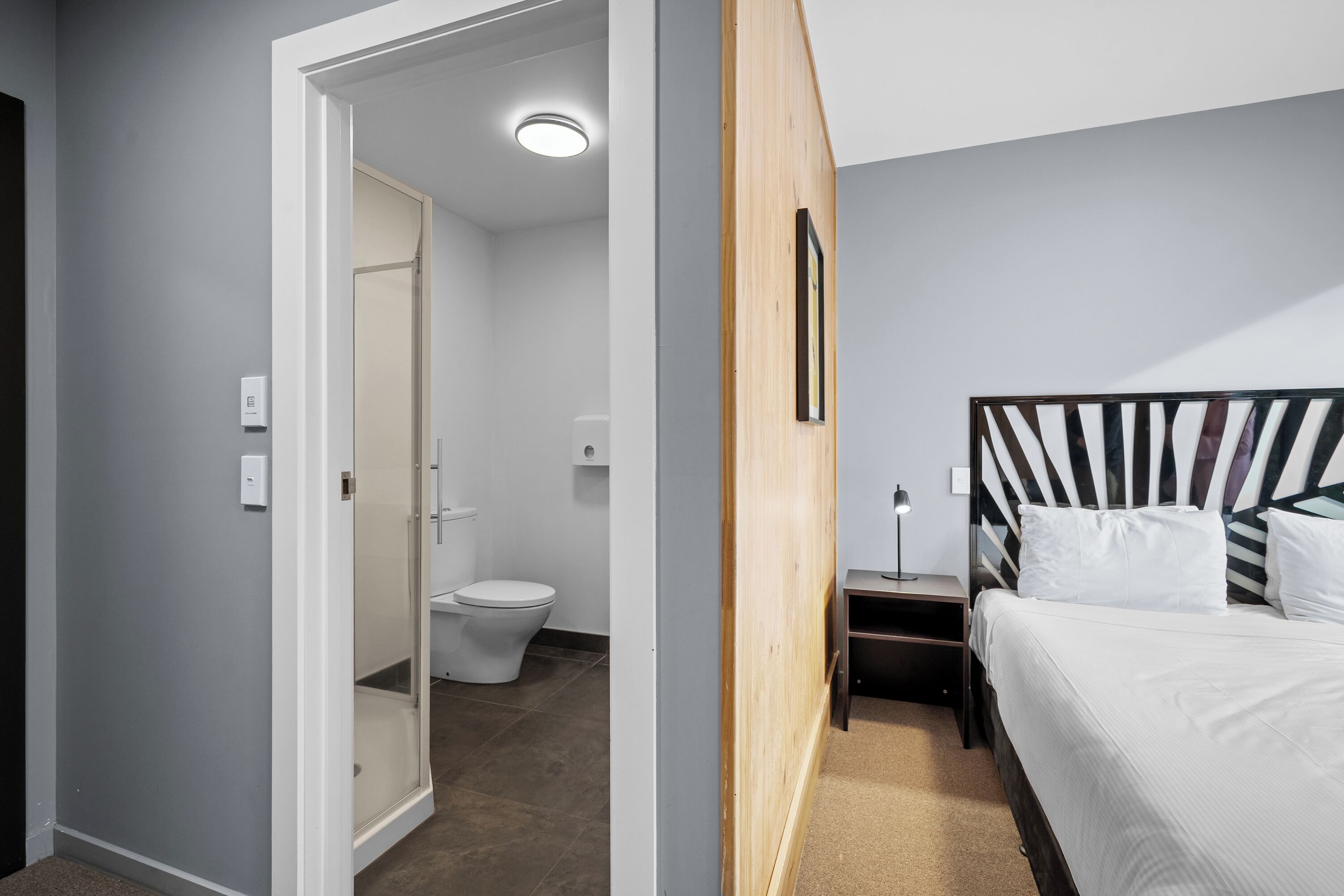 Ein Schlafzimmer mit Bett, Nachttisch und Holz-Kopfteil.