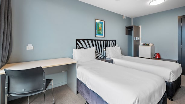 A hotel room with two beds, a desk, and a chair. - Bealey Quarter (Christchurch)