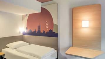 Ein Hotelzimmer mit einem Bett, einer Wandablage und einem Stadtbild-Wandgemälde.