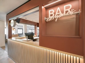 Una moderna recepción con un letrero que dice 'BAR', un letrero que dice 'B&B' y un letrero que dice 'todos'.