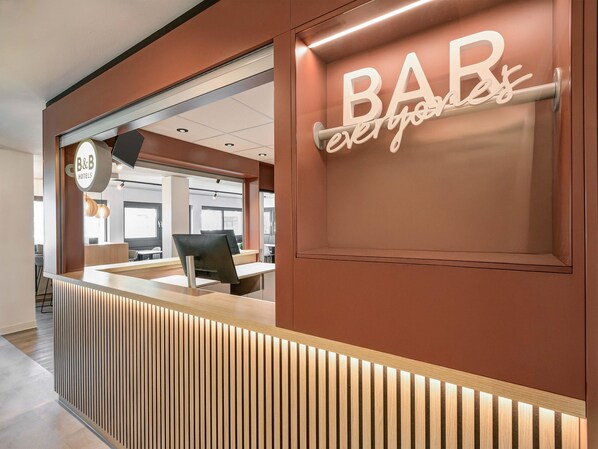 A modern reception desk with a 'BAR' sign, a 'B&B' sign, and a 'everyone' sign. - B&B HOTEL Kassel-Lohfelden (Lohfelden)
