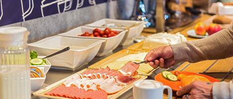 A buffet with various food options including meats, fruits, and condiments.