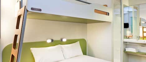 Una cama litera con cabecera verde y dos lámparas de noche.