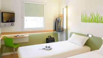 Une chambre d’hôtel avec deux lits, un bureau, une chaise, une télévision et une fenêtre donnant sur un beau paysage.