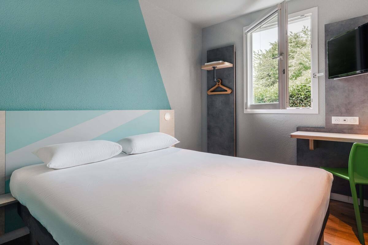 Un dormitorio moderno con una cama, un escritorio y una silla.