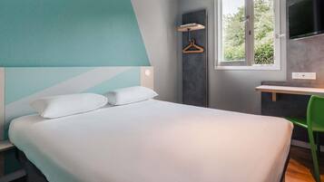 Ein modernes Schlafzimmer mit Bett, Schreibtisch und Stuhl.
