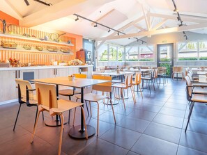 Un restaurante moderno con un interior luminoso, una barra con diferentes productos alimenticios y vistas al exterior a través de amplios ventanales.