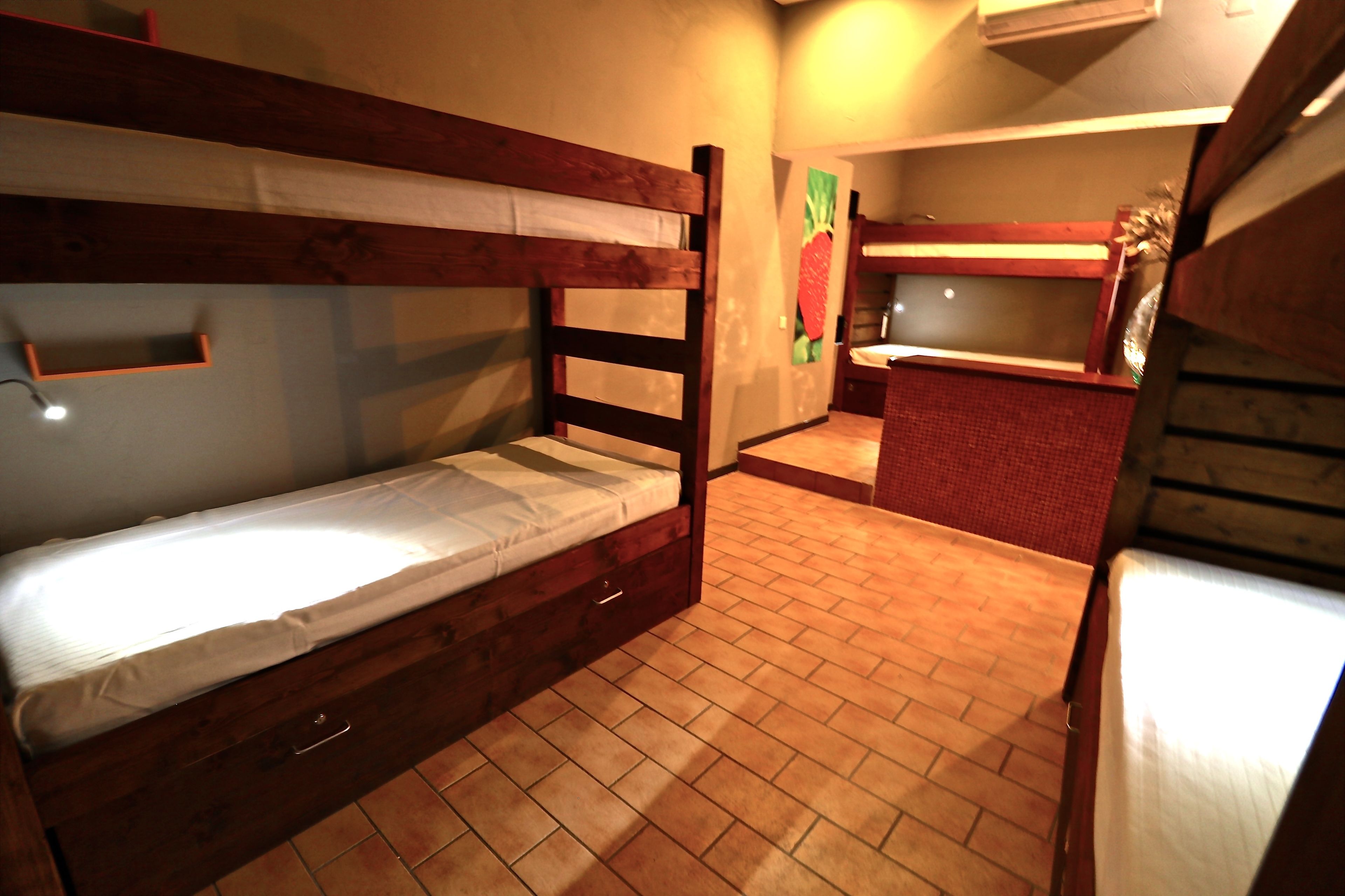 A bunk bed room with a small kitchen area.