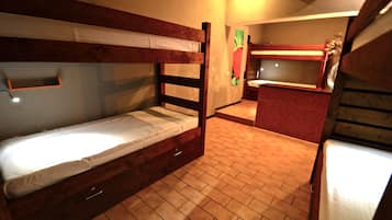 A bunk bed room with a small kitchen area.