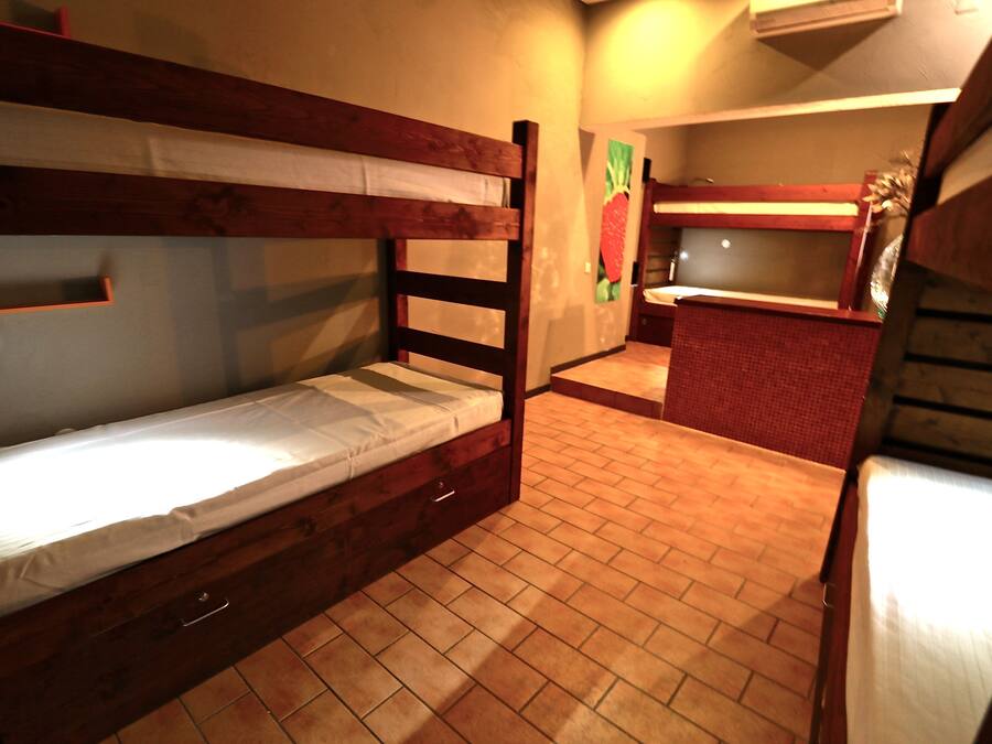 A bunk bed room with a small kitchen area.