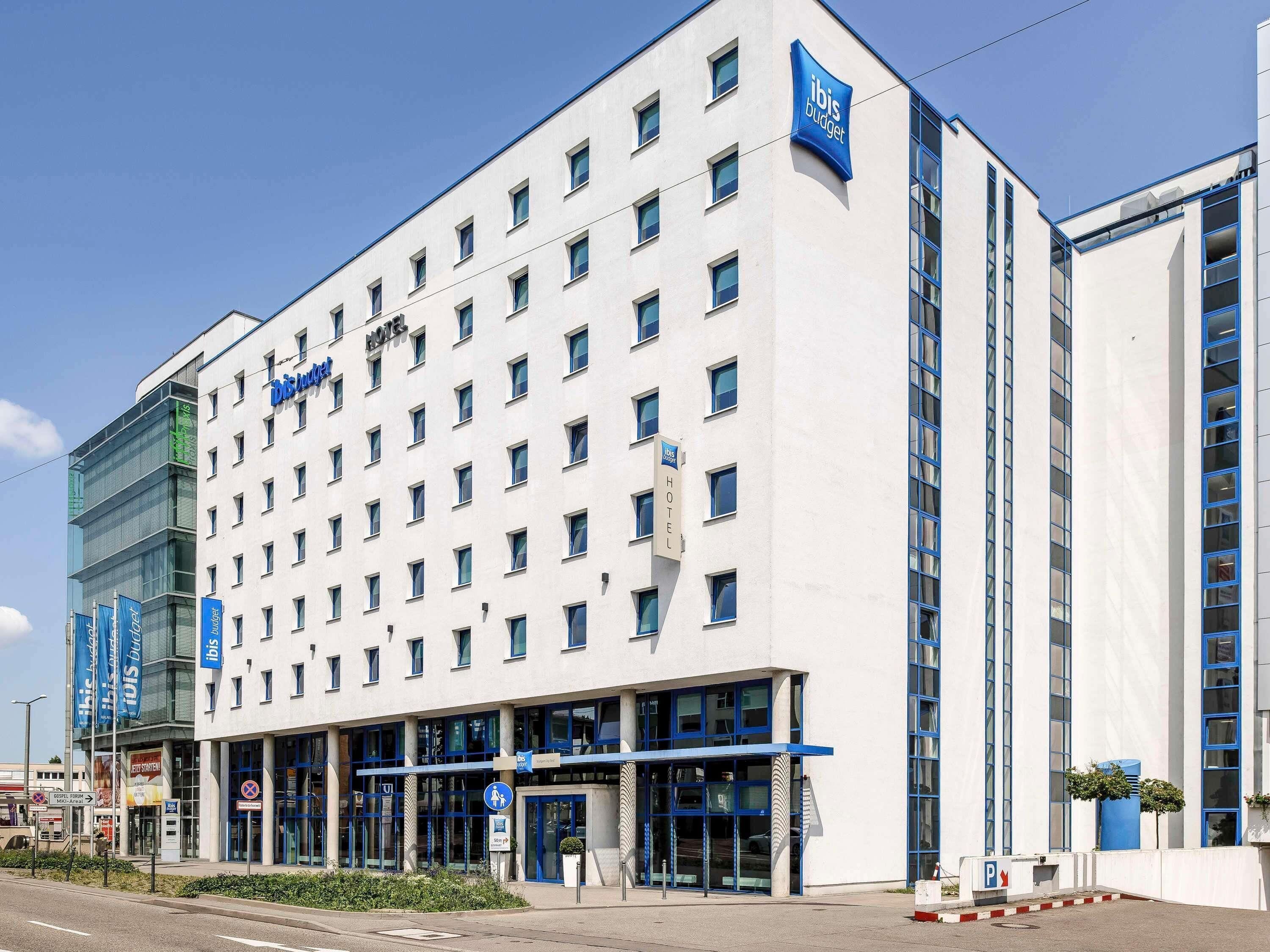 Un hôtel moderne, avec plusieurs étages, une entrée imposante et un ciel dégagé.