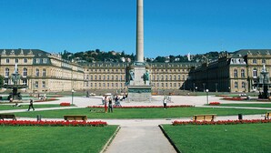 A large open plaza with a tall monument, surrounded by historic buildings and a well-maintained garden with benches. - Ibis Budget Stuttgart City Nord (Stuttgart)